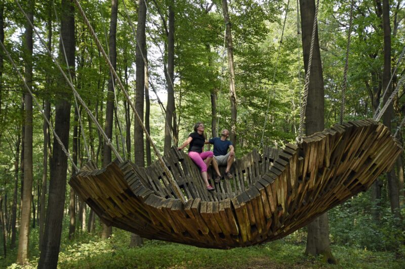 Wandelaars zitten op het kunstwerk Windwiege in het Teutoburgerwald