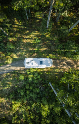 Camper rijdt door het bos.